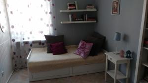 a room with a bed with purple pillows on it at W kamienicy in Gdańsk