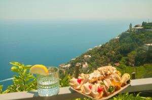 a plate of food and a glass of water on a balcony at Casa Martina in Amalfi