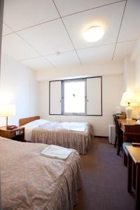 A bed or beds in a room at Ryogoku River Hotel