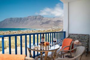 een balkon met een tafel en 2 glazen wijn bij Famara Views in Famara