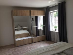 バート・ハルツブルクにあるFerienwohnung Unikat Harzのベッドルーム1室(大きなガラスのキャビネット、ベッド1台付)