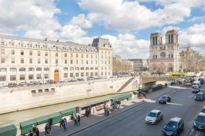 パリにあるTwo Bedroom Luxury Apartment - Balcony with View of Notre Dameの車や建物、橋が並ぶ賑やかな街道