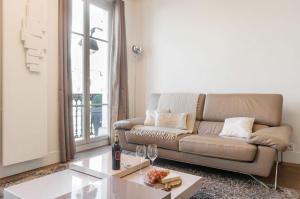 a living room with a couch and a table at Two Bedroom Luxury Apartment - Balcony with View of Notre Dame in Paris