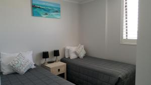 a bedroom with two twin beds and a window at Banyandah Towers in Maroochydore