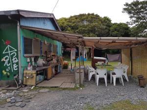 ein Gebäude mit einem Haufen Stühle und einer Terrasse in der Unterkunft Tomarigi in Yakushima