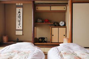 a bedroom with two beds and a shelf at Komachiya in Kyoto