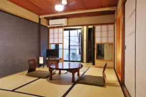 uma sala de estar com mesa e cadeiras em Komachiya em Quioto
