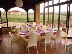 a dining room with a table and chairs and windows at Posada La Torre de los Isla & Spa in Beranga