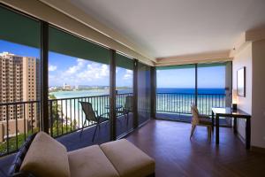 
a living room with a balcony overlooking the ocean at Guam Reef Hotel in Tumon
