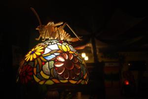 una lámpara de vidriera con una flor. en Dulan The Travel Bug Bistro Inn en Donghe