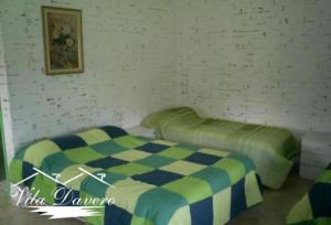 a bedroom with a bed with a checkered blanket at Si­tio Vila Davero in Socorro