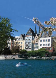 ein Boot im Wasser vor einem Gebäude in der Unterkunft Hotel Römerhafen in Köln