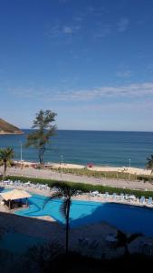 a view of a resort with a swimming pool and a beach at Flat Villa Del Sol-Praia da Macumba in Rio de Janeiro