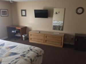 1 dormitorio con 1 cama, vestidor y TV en Chaffee Lodge, en Chaffee