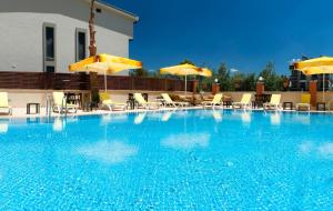 uma grande piscina azul com cadeiras e guarda-sóis em Asmira Royal Hotel em Gumuldur