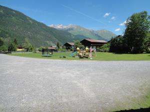 a parking lot with a playground with mountains in the background at Appartement Romy in Bach