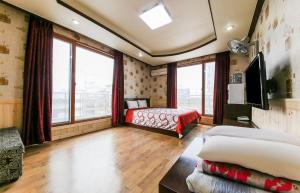 a bedroom with a bed and a large window at Venus Motel in Boryeong