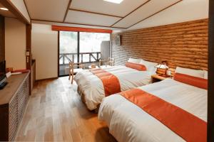 a hotel room with two beds and a television at Hotel Fuki no Mori in Nagiso