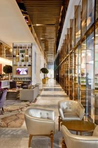 a lobby with couches and tables in a building at THE FACE Suites in Kuala Lumpur