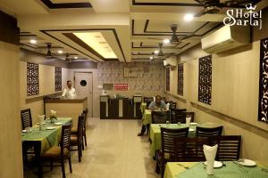 a dining room with people sitting at tables in a restaurant at Hotel Sartaj in Dera Bassi
