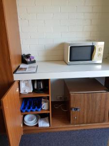 un four micro-ondes assis au-dessus d'une table dans l'établissement Motel Traralgon, à Traralgon