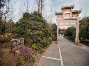 a entrance to a park with a sign and a gate at Yurong West Lake Cottage Resort Hotel Hangzhou in Hangzhou