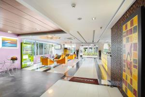 a lobby of a building with yellow and pink walls at Klassique Sukhumvit in Bangkok