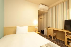 a hotel room with a bed and a tv at Hiyori Hotel Maihama in Urayasu