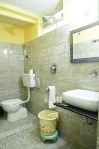 a bathroom with a sink and a toilet and a tub at Bani Park Hotel in Jaipur