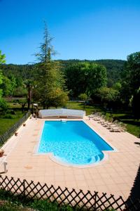 una gran piscina con sillas y una valla en Domaine De La Provenç'âne, en Salernes