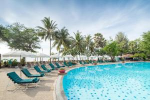 una piscina in un resort con sedie e palme di Regent - Chalet, Hua Hin a Petchaburi