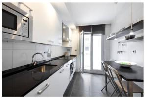 uma cozinha branca com um lavatório e um balcão em White Cozy Flat in Donostia em San Sebastián