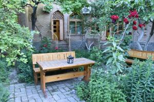 a wooden bench sitting in the middle of a garden at ANTICA Family Guest House in Samarkand