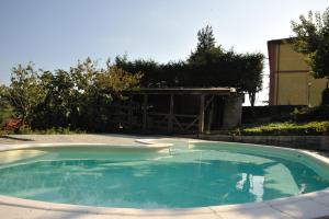 a large swimming pool in a yard with a building at Villa Eugenia in Cairo Montenotte