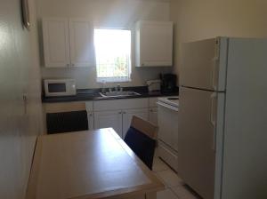 a kitchen with a white refrigerator and a table at Birch Patio Motel in Fort Lauderdale