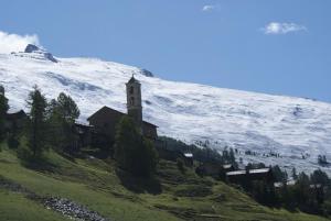 a church on the side of a snow covered mountain at Le Berger Gourmand in Saint-Véran