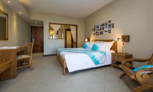 a bedroom with a bed and a table and a chair at C Mauritius in Belle Mare