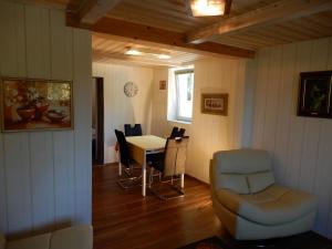 a living room with a table and chairs and a chair at Chalet Herenhuet in Brienz