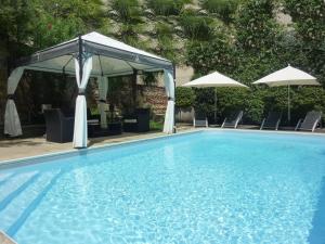 - Piscina con dosel, sillas y sombrillas en Hotel de France, en Bergerac