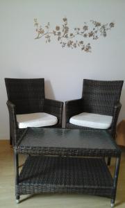 - 2 chaises en osier et une table dans une pièce dans l'établissement Apartment Kristijan, à Pag 1 autre photo
