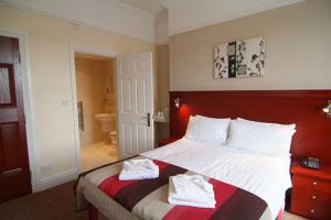 A bed or beds in a room at Kensington Hotel 