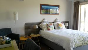 a bedroom with a bed and a chair and a window at Austiny Bed and Breakfast Victor Harbor in Victor Harbor