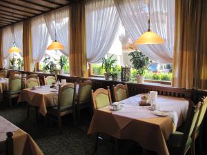 a restaurant with tables and chairs and a window at Hotel Garni Lawens in Serfaus