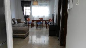 a living room with a couch and a table and chairs at Piso Geneto con garaje in Las Lagunas
