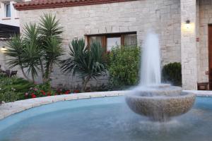 a fountain in the middle of a swimming pool at Nostos Hotel in Afitos