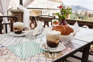 una mesa con dos bebidas y algunos pasteles en ella en Avocado B&B Beyond, en Giardini Naxos