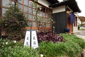 a garden with two signs in the grass at Hoshikuzu in Naoshima