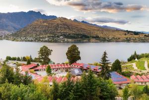 a resort on a lake with a mountain in the background at Sherwood in Queenstown