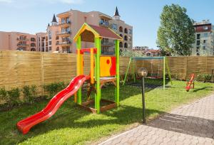 a playground with a slide in the grass at Calypso Hotel - All Incluisve in Sunny Beach