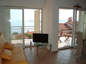 a living room with a couch and a television on a balcony at Apartment Golf in Crveni Vrh